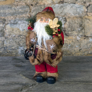 Santa red coat with check pattern carrying his Skis and a Lantern